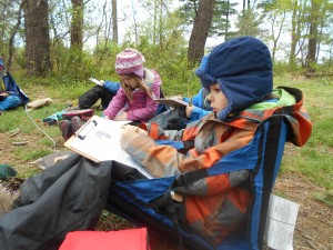 children writing in their nature journals on Forest Fridays at Ridge and Valley Charter School